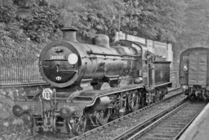 black and white image of locomotive on tracks.