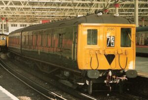 green and yellow electric train in a station.