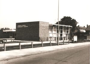 large brick building with writing on side which reads 'Langley Green Community Centre'.