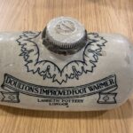 Stone hot water bottle, with text on front that reads 'Doultons Improved Foot Warmer, Lambeth Pottery, London'