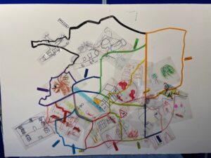 White board with map marked out with coloured lines. Drawing of local places attached.
