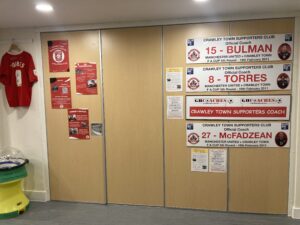 Long, red and white signs stuck to brown doors, 4 in total.