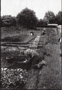 Black and white photograph of a field with bits of soil dug up.
