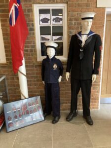 Two manikins dressed in dark blue uniforms.