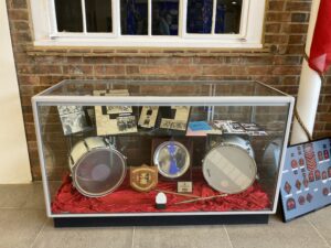 Display case with drums and other objects inside.