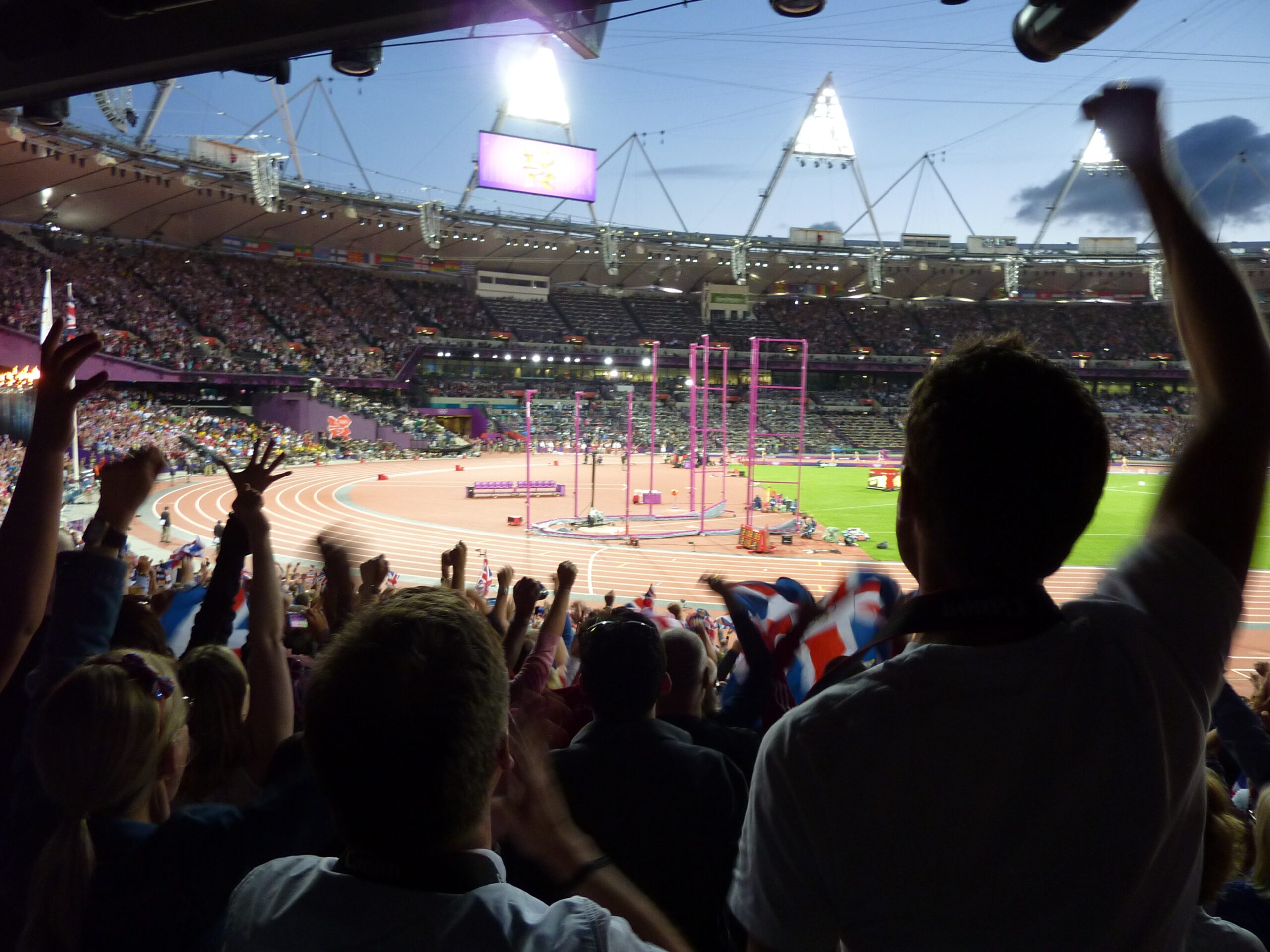 Colour photograph of crowd with running track in front of them. 