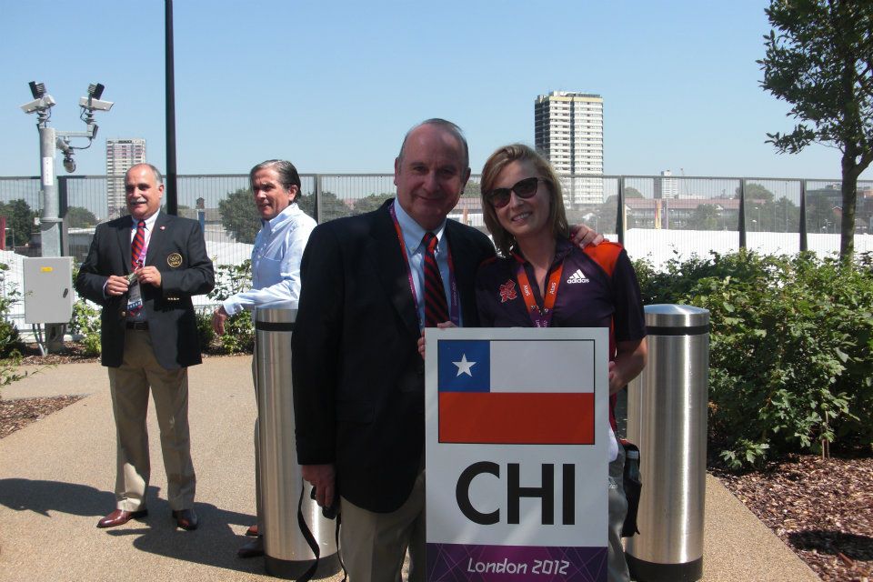 A man and a woman stand together outside looking at the camera. 