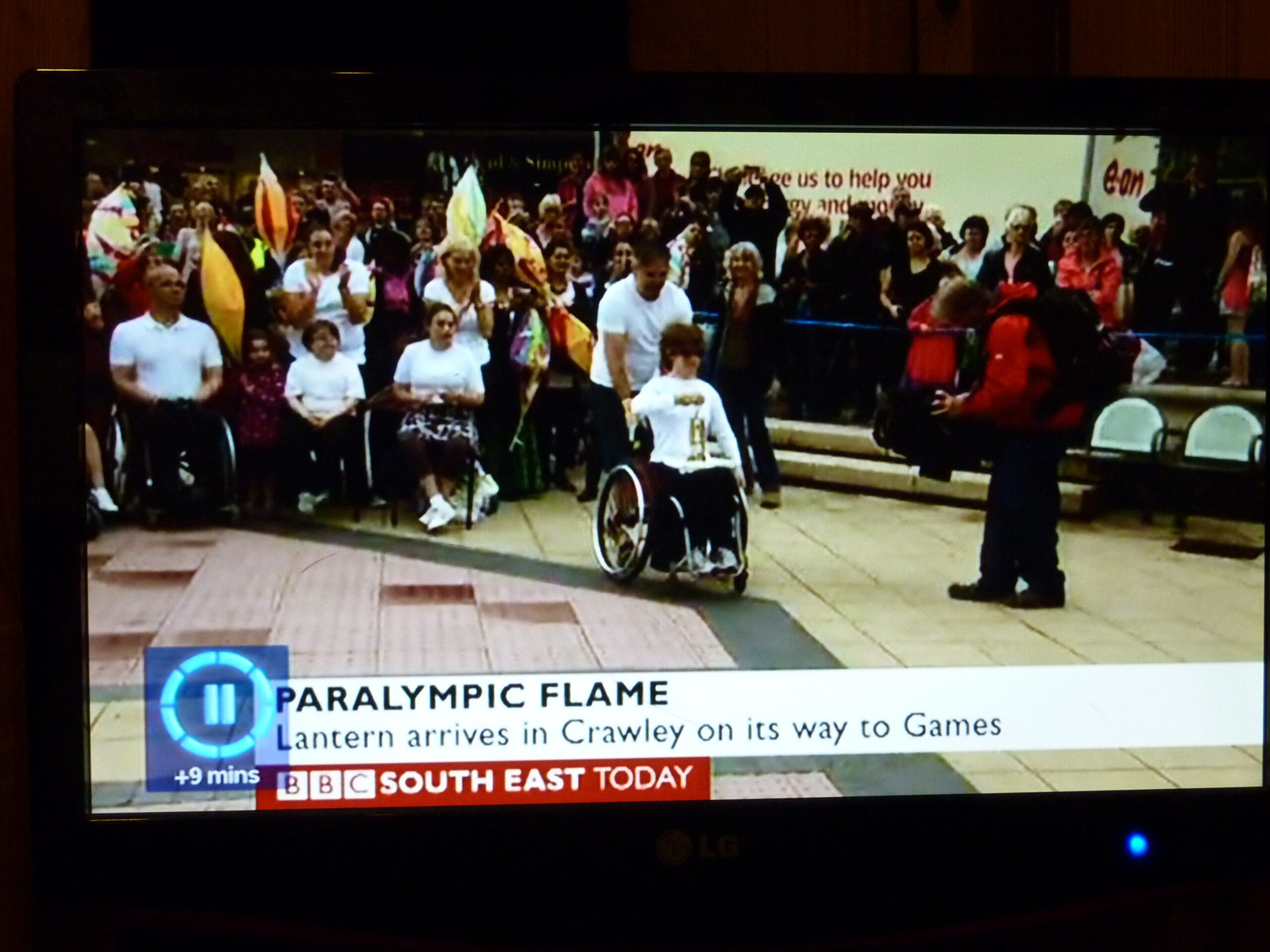 Still image from BBC South East Today showing group of people celebrating the Paralympic Flame.